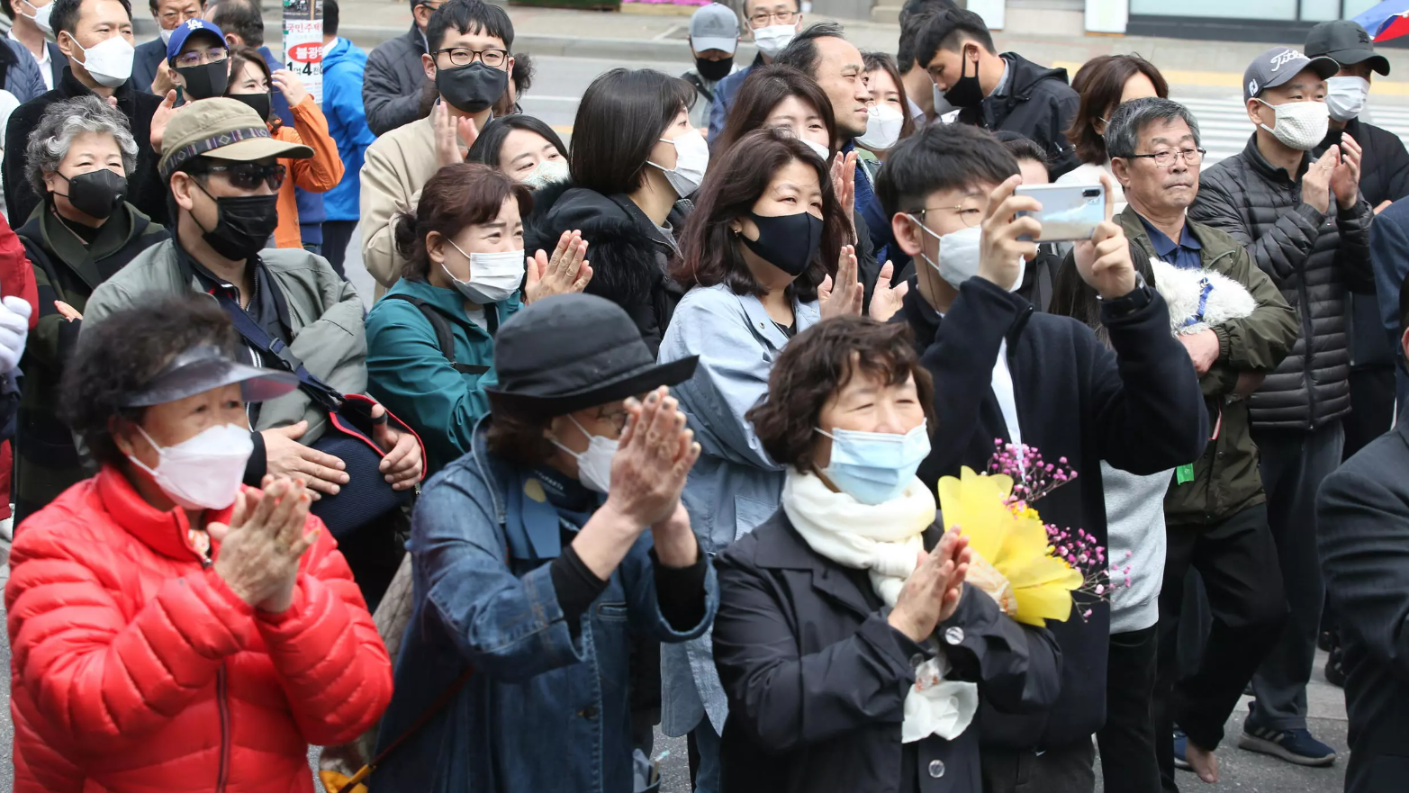  Electores surcoreanos saludan a Lee Nak-yon (no en la foto), exprimer ministro del país y actual copresidente del grupo de trabajo electoral del gobernante Partido Demócrata, durante un mitin de campaña en Seúl, Corea del Sur, el 12 de abril de 2020. © Kim Chul-Soo / EFE 